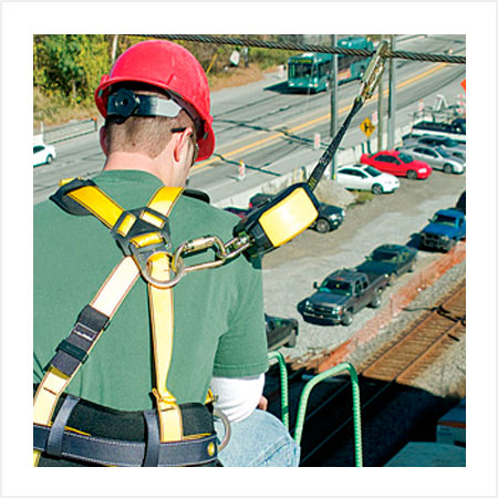 Construction worker wearing safety harness for working at heights